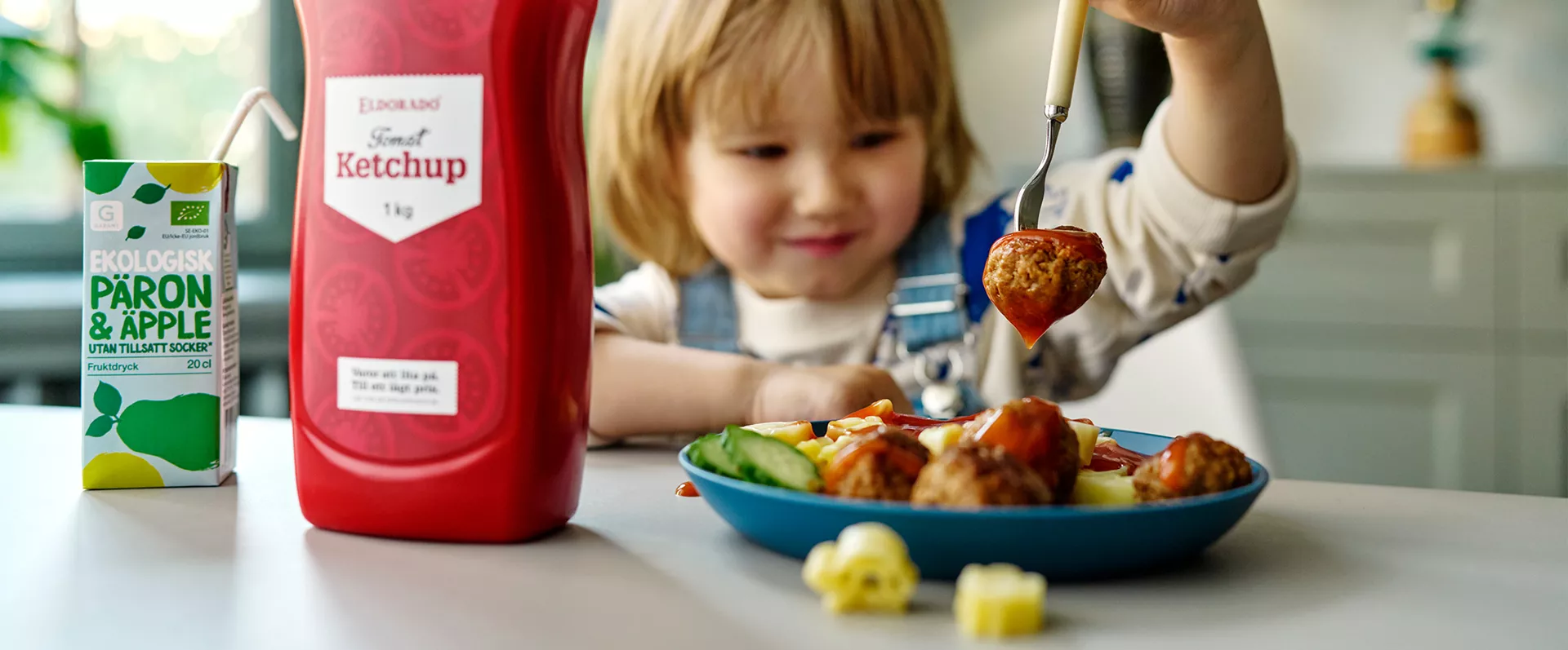 A little kid eating meatballs from Garant