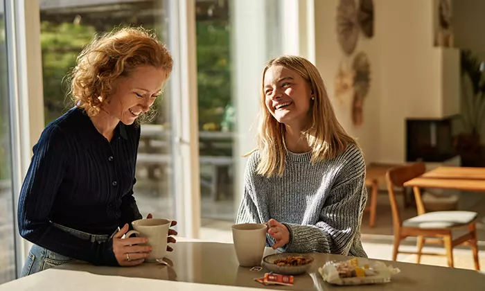 Two people drinking tea in a kitchen